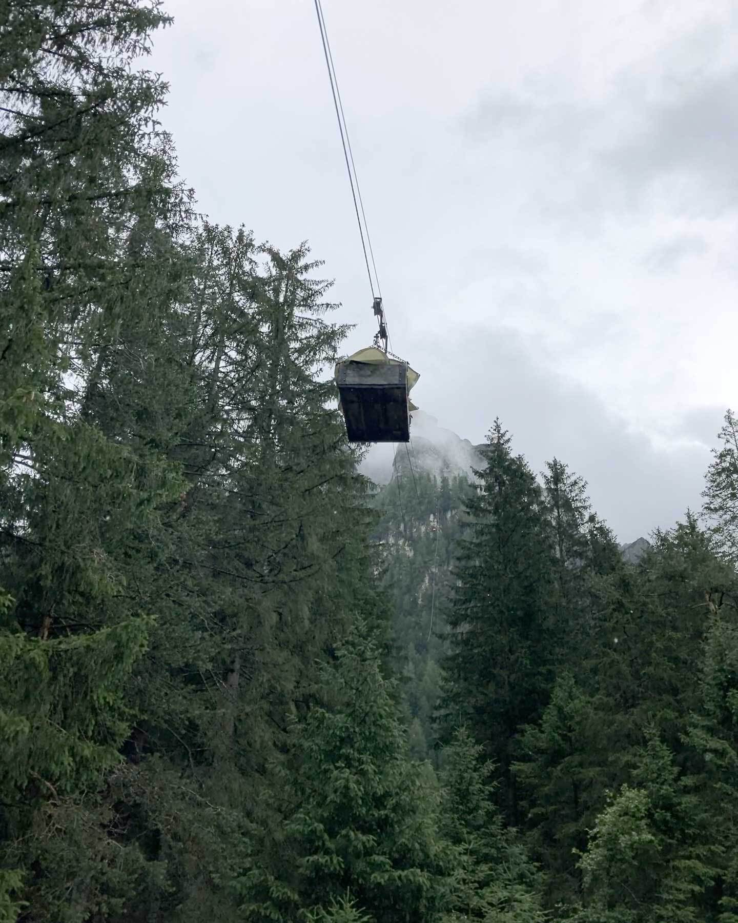 Eine Materialseilbahn vor Nebel und Nadelwald.