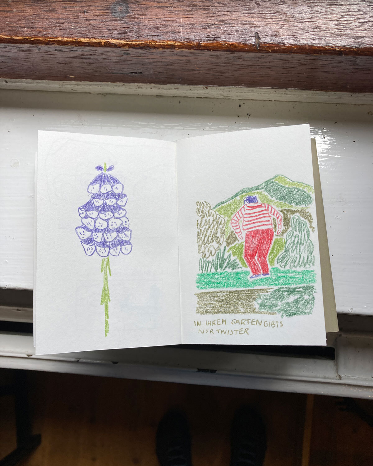 Skizzenbuch. Mit Buntstiften gezeichnete Glockenblumen und tanzende Frau im Garten